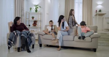 Çocukları yla mutlu anne ve bir büyükanne oturma odasında birlikte vakit geçiriyorlar sanal gerçeklik gözlüğü yle oynuyorlar, onları giyen bir çocuk ve yeni bir teknoloji keşfediyorlar..