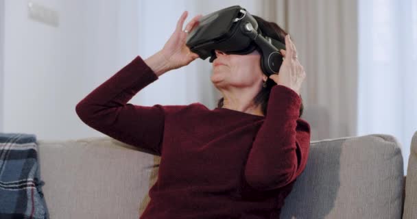 Velha geração uma mulher na idade usando pela primeira vez um óculos de realidade virtual ela está muito impressionada com esta nova tecnologia — Vídeo de Stock