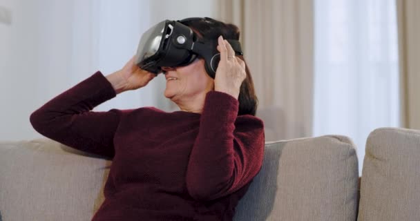 Харизматичная старуха, впервые пользующаяся очками виртуальной реальности, очень воодушевлена и впечатлена прогрессом этой новой технологии. — стоковое видео