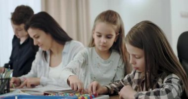 Çocukları ile Closeup anne birlikte çizim ve oturma odasında bir masa oyunu oynarken zaman harcama , çok güzel bir atmosfer