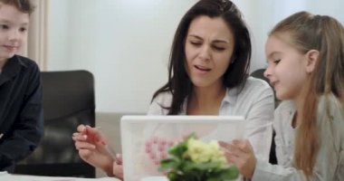 Büyük bir gülümseme ile güzel iyi anne bir masa oyunu boyama birlikte oynarken çocukları ile güzel bir zaman harcama