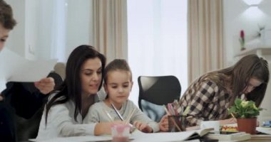Büyük bir gülümseme ile Anne birlikte iyi vakit geçirdikten sonra oturma odasında çocukları ile bir el sanatları zaman var