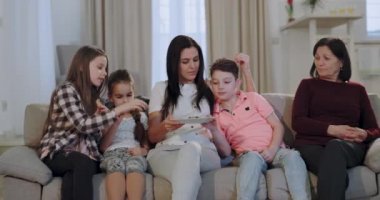 Kızı ve torunları ile büyük bir aile büyükanne üzerinde iyi bir atmosfer onlar snack için bazı bisküvi almak ve birlikte zaman zevk tv bir film izlemeye başlamak için hazırlanıyor