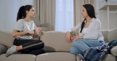 Closeup olgun kadın dinlekanepede oturan ve önemli bir konuşma var onun genç kız kardeşi konsantre
