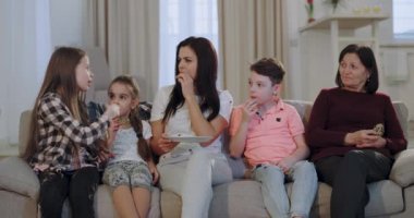 Kamera önünde bazı bisküvi yerken onu üç çocuk ve bir büyükanne film izlerken çekici kadın, onlar güzel bir konuşma ve gülümseyen yüzleri var