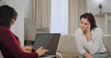 Kanepede çok üzgün bir hasta psikolog ile sohbet var yaşlı bir kadın o not defterine yazarken hasta sorunu söyler