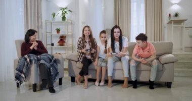 Çok konsantre ve karizmatik anne kanepede oturan kamera önünde bir video oyunu çocukları ile oynarken anne o bir kanepede oturan düzeyi büyükanne geçmiyor üzgün ve