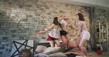Yatıya partipijama dans bayanlar , modern bir kentsel yatak odası tasarımı eğlenceli bir zaman var , yatağın üzerinden atlama ve büyük duygu