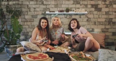 Yatıya gece de playstation oyununda oynayan güzel bayanlar pizza yiyip pijamalarıyla birlikte iyi vakit geçiriyorlar.