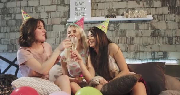 Grupo de señoritas celebrando fiesta de cumpleaños en casa en el dormitorio con copas de champán y sombrero de cumpleaños . — Vídeos de Stock