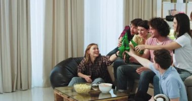 Futbol maç zamanı çok etnik arkadaş grubu için kendi takım onlar bağırıyor ve tv önünde geniş bir yaşam otururken el çırparak zafer olsun heyecanlıyız