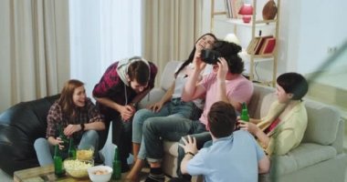 Gülen ve çekici yetişkin arkadaşlar çok etnik bir grup birlikte iyi vakit geçirmek bunlardan biri vr oynamak , onlar bira içme ve zaman zevk