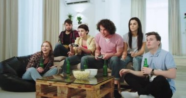 Oturma odasında çok heyecanlı çok etnik arkadaşlar iki arkadaş bir video oyunu nasıl izliyor , bazıları kazanan vardır