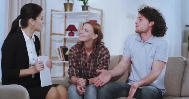 Woman house agent make a deal with a young couple after they discuss the term of a house rent at the end they shaking hands — Stock Video
