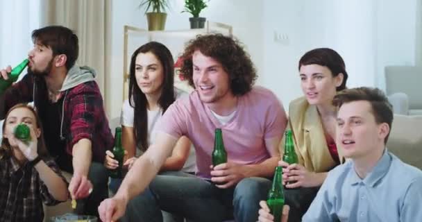 Grupo de close-up de amigos multi étnicos comemorando a vitória de seu melhor time de futebol na frente da TV eles assistindo o jogo muito animado — Vídeo de Stock