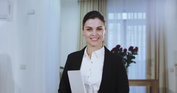 Portrét usmívající se obchodné ženy na neformální kombinéze, která hledí přímo do kamery, má velký bílý úsměv a drží tablet — Stock video