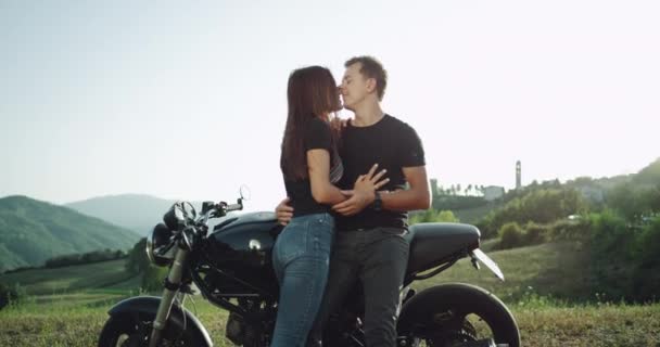 No meio de uma paisagem incrível um casal passar um tempo lindo juntos ao lado de uma motocicleta — Vídeo de Stock