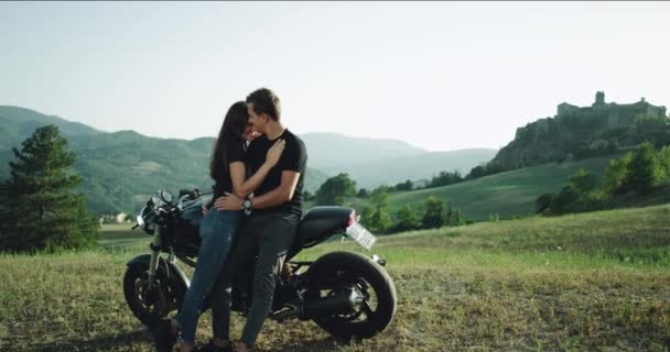 Em um dia de verão casal carismático passar um tempo encantador no meio da natureza ao lado de sua motocicleta. movimentos lentos — Vídeo de Stock