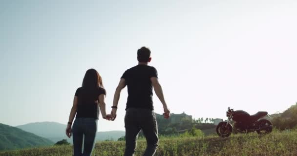 In verbazingwekkende mooie landschap jong stel arriveerde met hun motorfiets en het verkennen van de plaats in een zomerse warme dag. — Stockvideo