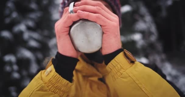 Portraitdetails von gefrorenen Händen, die eine eiserne Tasse halten, Touristenmann wird inmitten des schneebedeckten Berges warm — Stockvideo