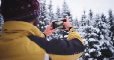 Dağın ortasında Turist , o karlı bir orman ağacı ile bir yer buldu , o anılar için fotoğraf çekmek
