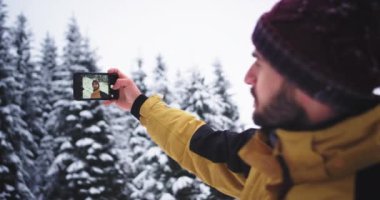 Dağda genç bir karizmatik turist için Selfie zaman inanılmaz karlı orman bulundu ve çok mutlu fotoğraf çekmek