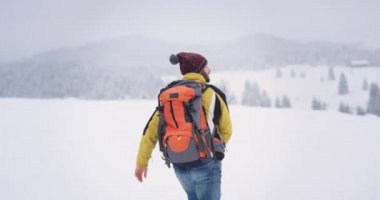 Donanımlı genç turist karlı alanda yürürken , o dağın tepesinde onun hedefe gitmek , etrafında şaşırtıcı manzara