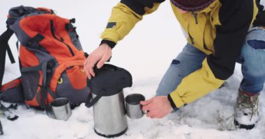 Ayrıntılar closeup turist adam sergi için her malzeme ile donatılmış, turist termos bir demir fincan içine sıcak bir çay dökün , o Sıcak almak istiyor