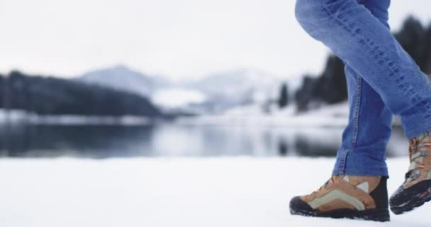 Detalles turísticos de las piernas caminando alrededor del lago de la orilla, turista vistiendo jeans y botas de montaña — Vídeo de stock