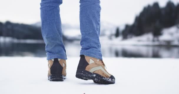 Портрет бегущего туриста, крупный план взяв только горные сапоги, фон удивительный пейзаж большого озера и снежной горы — стоковое видео