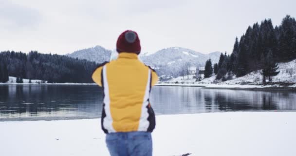 Courir touriste heureux au grand lac avec une carte heureux, il est arrivé à sa destination, il jette la carte et très heureux de sauter à côté du lac de rivage, vue imprenable sur la montagne et la forêt autour — Video