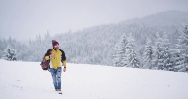 Karlı alanda turist Yürüyüş, sıcak çay ile bir fincan tutarak sıcak almak için , arka plan karlı orman ve dağ üzerinde güzel manzara