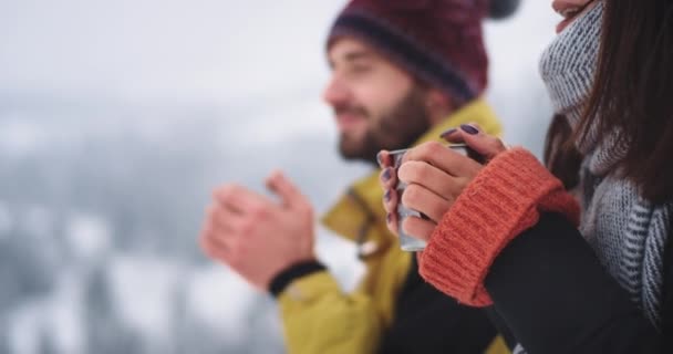 Primeros planos mujer y chico en un lugar increíble en medio de la montaña, beber té caliente de la taza de hierro y admirar la atmósfera del paisaje, sonriendo a lo grande — Vídeos de Stock