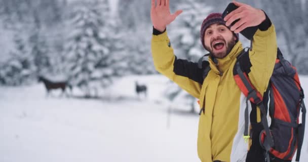 Dağ ve karlı ormanın ortasında mutlu karizmatik turist atları ile selfie alarak, akıllı telefon kullanarak — Stok video