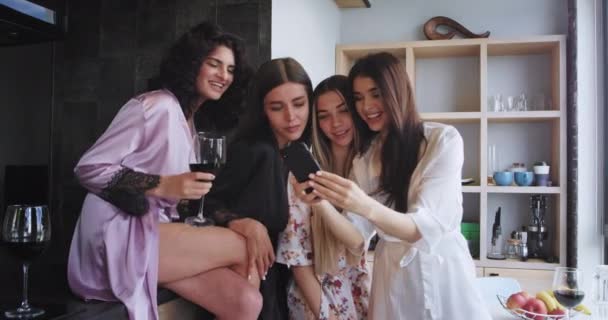 Mosolygó nagy karizmatikus hölgyek stílusos pizsama előkészítése bachelorette fél ivott egy kis bort, és átnézett a smartphone — Stock videók