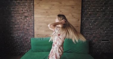 Şehir tasarımı ile oturma odasında kamera önünde sabah pijama dans uzun saçlı güzel güzel bayan. 4k