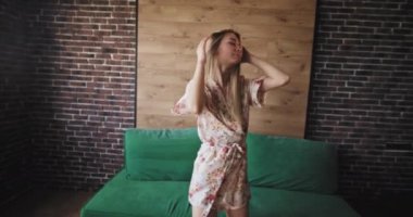 Pembe çiçekli pijama güzel kadın onu kentsel stüdyo dairede kamera önünde sabah mutlu dans