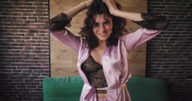 Büyük bir ruh hali dans ve onu kentsel tasarım stüdyosunda pijama atlama ile sabah büyük bir gülümseme ve kıvırcık saçlı kamera güzel bayan önünde