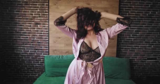 Aantrekkelijke vrouw met een krullend haar in de ochtend dansen gelukkig in de voorkant van de camera springen en gevoel geweldig in pyjama ze glimlachend groot — Stockvideo