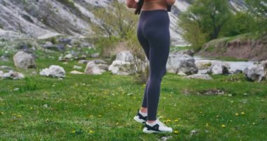 Doğada inanılmaz bir yerde egzersiz sonrası Çekici güzel sportif bayan taşlar arasında yürüyüş ve güzel bir görünüm yanında oturan ve akıllı telefon kullanarak bazı selfie'ler çekmek