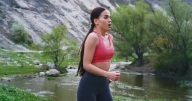 O büyük bir nehrin yanında kamera önünde dururken o bacaklar germe çalışan sonra inanılmaz manzara genç bayan ile doğanın ortasında spor uygulama. 4k