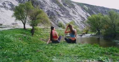 Büyük taşlar ile inanılmaz bir yeşil görünümünde iki bayan bir nehir yanında bir mola zaman var sert bir egzersiz egzersizleri sonra birlikte zaman zevk
