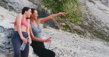 Gülümseyen çekici iki genç kadın spor rutin sonra doğanın ortasında birlikte zaman zevk onlar temiz havada bazı durgun su içme zaman zevk