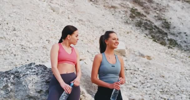 Две подруги юные леди улыбаются и чувствуют волнение после тяжелого тренировочного дня у них есть перерыв в середине удивительного ландшафта на природе — стоковое видео