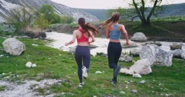 Harika manzara görünümü ortasında sert iki spor kadın koşu bir mola ve çevresinde görünümü zevk biraz durdu. yavaş hareketler