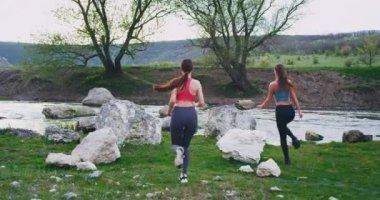 Sert bir egzersiz bir mola için durdu ve etrafında görünümü zevk sonra dağ ve nehir iki bayan muhteşem manzara ortasında arkadan video alarak