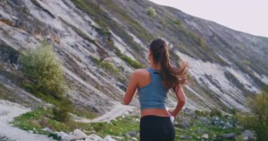 O taşlar yol ile sert çalışan dağın ortasında onu egzersiz yapıyor Sportif genç kadın , şaşırtıcı manzara görünümü