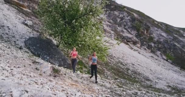 Gülümseyen karizmatik iki bayan Mountain View ortasında taş yol ile doğada sert bir egzersiz var — Stok video