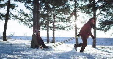 İyi görünümlü çift karlı bir ormanın ortasında onlar kızak ile bir yolculuk var ve zaman zevk kar topları ile aynı anda oynarken büyük bir zaman var