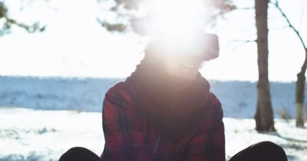 Sur un traîneau à l'extérieur gros plan gars charismatique à l'aide d'une réalité virtuelle lunettes pour jouer à un jeu qu'il se sent dans une promenade fantastique tout en étant assis sur le traîneau — Video